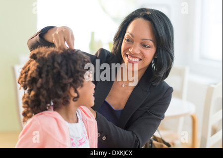 African American mother fixing daughter's hair Banque D'Images