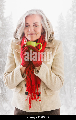 Caucasian woman drinking hot chocolate outdoors Banque D'Images