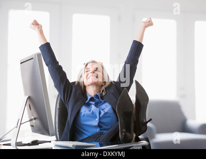 Happy Caucasian businesswoman avec pieds sur 24 Banque D'Images