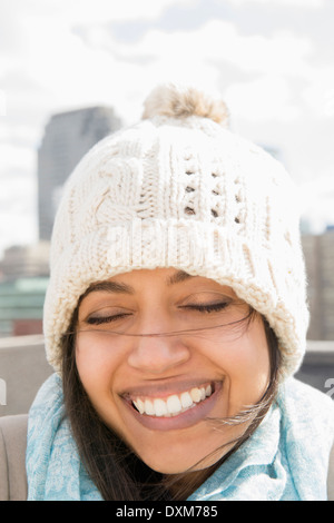 Close up of Asian woman smiling in Knit hat avec les yeux fermé Banque D'Images