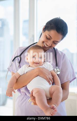 Nurse holding smiling baby Banque D'Images