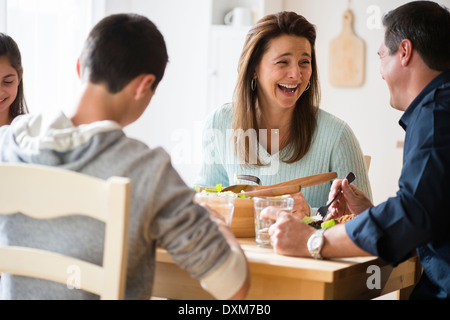 La famille caucasienne de rire et de manger à table Banque D'Images