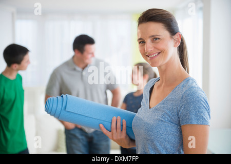 Portrait of smiling woman holding yoga mat Banque D'Images