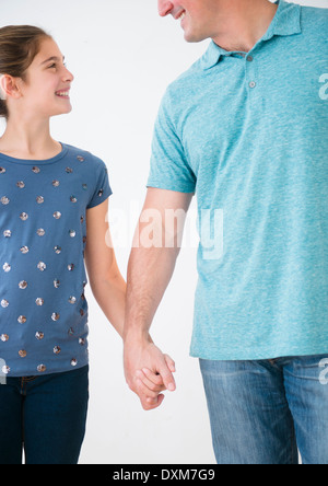 Smiling Caucasian father and daughter holding hands Banque D'Images