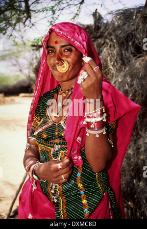 Femme indienne portant des bijoux en or et rose foulard dans un village près de Jodhpur, Inde. Image manipulée numériquement Banque D'Images