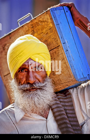 Personnes âgées indien avec une barbe grise portant un turban jaune et portant un fort sur son épaule à Jodhpur, Inde Banque D'Images