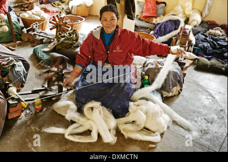 Tibetan refugee woman filage de la laine à Katmandou, Népal Banque D'Images