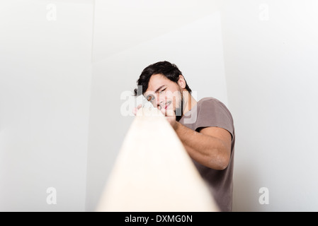 Jeune homme qui travaille à la maison bricolage Banque D'Images