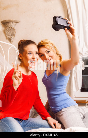 Deux filles faisant eux-mêmes photo dans une chambre Banque D'Images