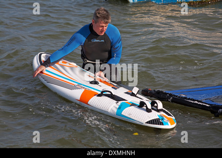 Windsurfer mise en place prêt à la planche à voile à Poole, Sandbanks en Mars Banque D'Images