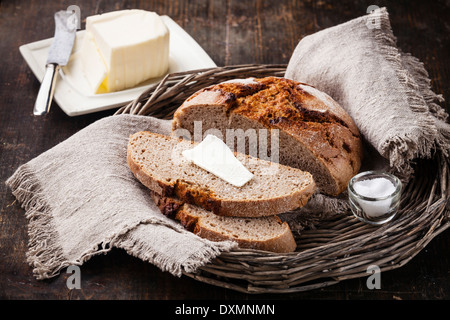 Des tranches de pain de seigle et du beurre sur table en bois