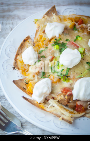 Une assiette de nachos mexicain avec des tortillas et de la crème sure Banque D'Images