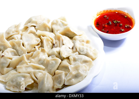 La cuisine chinoise : boulettes bouillies avec la sauce sur un fond blanc Banque D'Images