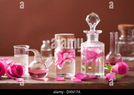 L'alchimie et l'aromathérapie avec des fleurs rose et flacons Banque D'Images