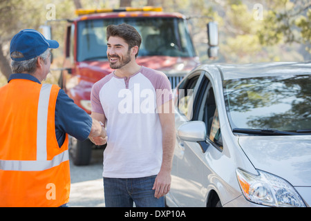 Man shaking hands with roadside mechanic Banque D'Images