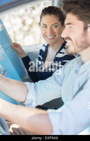 Couple heureux avec la carte à l'intérieur de voiture Banque D'Images