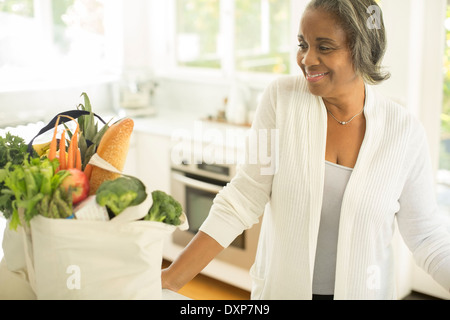 Smiling senior femmes avec des provisions dans la cuisine Banque D'Images