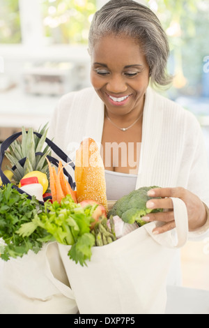 Happy senior woman unpacking groceries Banque D'Images