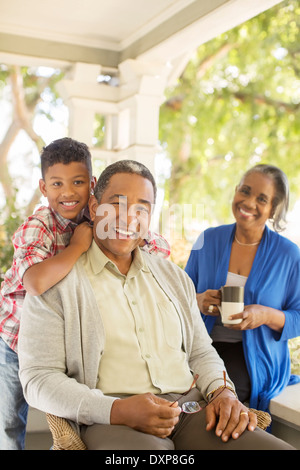 Portrait of smiling grands-parents et petit-fils sur le porche Banque D'Images