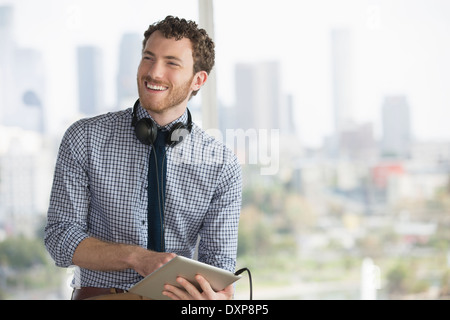 Happy businessman with digital tablet et écouteurs Banque D'Images