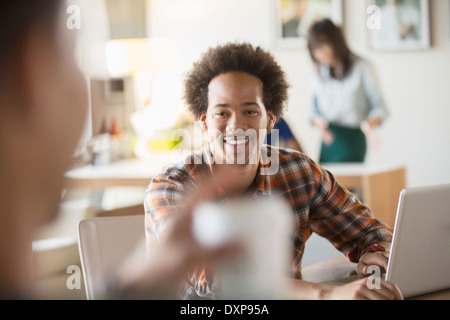 Heureux creative businessman using laptop in meeting Banque D'Images