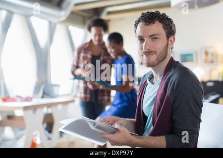 Portrait of smiling businessman with paperwork in office Banque D'Images