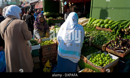 Les femmes musulmanes d'acheter des légumes à Whitechapel Road Market East London, UK KATHY DEWITT Banque D'Images