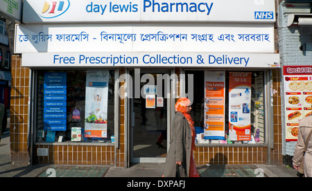 Femme musulmane devant jour Lewis Pharmacy extérieur sur Whitechapel Road à East London E1, UK KATHY DEWITT Banque D'Images