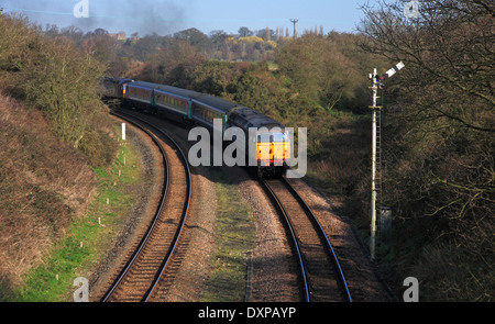 Un train de voyageurs sur l'approche de le pont tournant à Reedham, Norfolk, Angleterre, Royaume-Uni. Banque D'Images