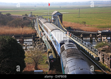 Un train de voyageurs traversant le pont tournant sur la rivière Yare à Reedham, Norfolk, Angleterre, Royaume-Uni. Banque D'Images