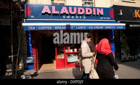 Asian women walking passé Alauddin Sweets Shop à Whitechapel Road East London E1 UK KATHY DEWITT Banque D'Images