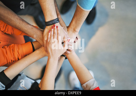 Groupe multiethnique des jeunes leur main sur le dessus de l'autre. Close up image de jeunes étudiants stacking hands. Banque D'Images