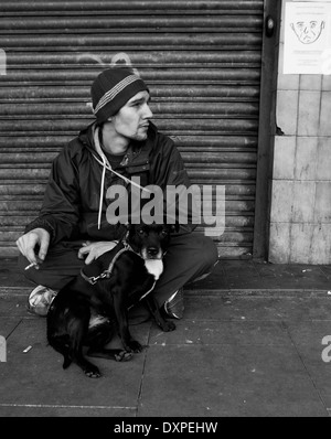 Sans-abri assis avec son chien dans les rues de Manchester. Banque D'Images