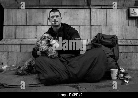 Sans-abri et son chien assis sur les rues de Londres. Banque D'Images