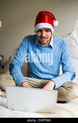 L'homme d'affaires élégant noël multitâche avec l'aide d'appareils à la maison Banque D'Images