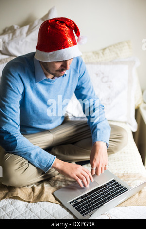 L'homme d'affaires élégant noël multitâche avec l'aide d'appareils à la maison Banque D'Images