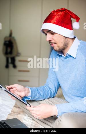 L'homme d'affaires élégant noël multitâche avec l'aide d'appareils à la maison Banque D'Images