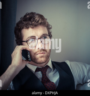 Mode attrayant élégant hipster homme au téléphone à la maison Banque D'Images