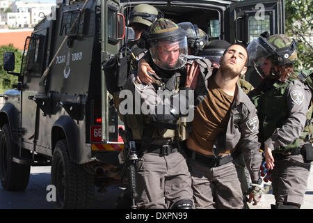 Cisjordanie, Palestine - 28 mars 2014 : des soldats israéliens aidant soldat après qu'il a été blessé par une pierre dans sa main dans Silwad, près de Ramallah. Un Palestinan arrestation et cinq Palestiniens ont été blessés par balles en caoutchouc et des gaz lacrymogènes, et, au cours de l'vendredi des affrontements entre manifestants palestiniens du village de Silwad, près de Ramallah et l'armée israélienne. (Photo par Abdalkarim Museitef/Pacific Press) Banque D'Images