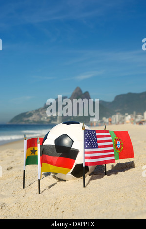 Le football international Groupe G pays drapeaux d'équipe avec ballon de soccer sur la plage d'Ipanema à Rio de Janeiro Brésil Banque D'Images