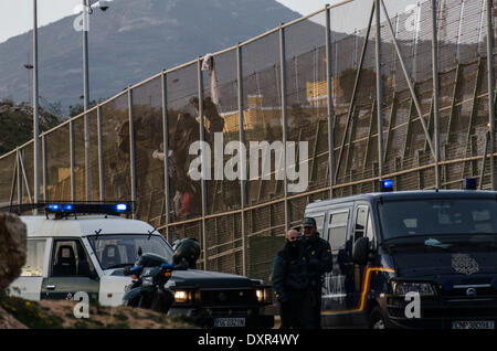 Melilla, Espagne. Mar 28, 2014. Les migrants subsahariens grimper sur une barrière métallique qui sépare le Maroc et l'enclave espagnole de Melilla, le vendredi 28 mars, 2014. Ont déclaré que plusieurs centaines de migrants africains ont tenté de franchir la frontière de barbelés des clôtures pour entrer dans l'enclave espagnole de Melilla du Maroc mais la plupart ont été refoulés par les forces de sécurité des deux côtés. Un porte-parole du Ministère de l'Intérieur a déclaré que les migrants en Melilla tenté d'escalader les clôtures plusieurs fois tôt le vendredi et une poignée a réussi à obtenir à travers. Des milliers de migrants qui cherchent une vie meilleure en Europe vivent illégalement dans Banque D'Images