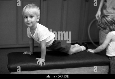 Berlin, DDR, petit garçon dans un Kindertagesstaette gymnastique n sur un fort Banque D'Images