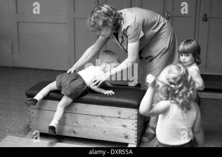 Berlin, DDR, petit garçon dans un Kindertagesstaette gymnastique n sur un fort Banque D'Images