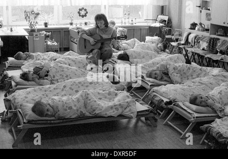 Berlin, DDR, enseignant de maternelle ensemble contre le poil des enfants à la guitare Banque D'Images