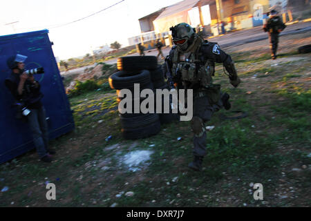 Ramallah, Palestinien. Mar 28, 2014. Des soldats israéliens au cours d'un runing protester contre la colonie juive d'Ofra, dans le village de Silwad, près de Ramallah Un palestinan arrestation et cinq Palestiniens ont été blessés par balles en caoutchouc et des gaz lacrymogènes, et, au cours de l'vendredi des affrontements entre manifestants palestiniens du village de Silwad, près de Ramallah et l'armée israélienne. © Museitef NurPhoto Abdalkarim //ZUMAPRESS.com/Alamy Live News Banque D'Images