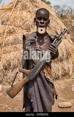 Femme Mursi avec la lèvre plate et dans la basse Kalachnikov Vallée de l'Omo d'Ethiopie. Banque D'Images