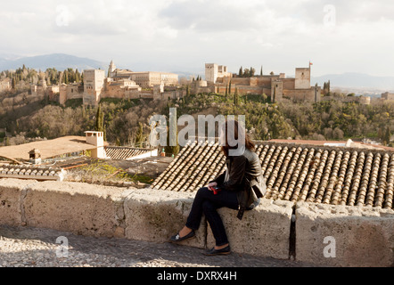Touriste à la recherche à la vue de l'Alhambra Palace au coucher du soleil depuis la place de St Nicolas, Grenade, Andalousie Espagne Europe Banque D'Images