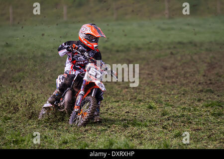 Motocyclisme sur piste de gazon de jeunes dans beaucoup de Hoole, Lancashire, Royaume-Uni Mars, 2014. Mickie Simpson MX65 pilote et gagnant à la première réunion de l'Association Lancashire Offroad Grasstrack qui s'est tenue à Lower Marsh Farm, à Rest Hoole, à Preston. Une course de moto junior, piste d'herbe, vitesse, vélo, moto, motorsport, puissance, gagnant, course, motocross, compétition, sports extrêmes, casque, roue, moto, sport, cavalier, cross, fun, saut, L'équitation, les sports, les sentiers, la saleté, la course rapide tenue en vertu du Code national du sport des règlements permanents de l'ACU pour les pistes herbeuses. Banque D'Images