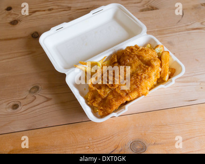 Poisson et frites à emporter dans une boîte en polystyrène sur une table en bois haut Banque D'Images