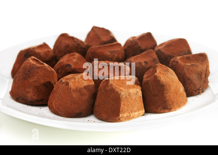 Truffes au chocolat, saupoudré de cacao sur une plaque blanche Banque D'Images